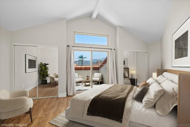 a bedroom with a large bed and windows