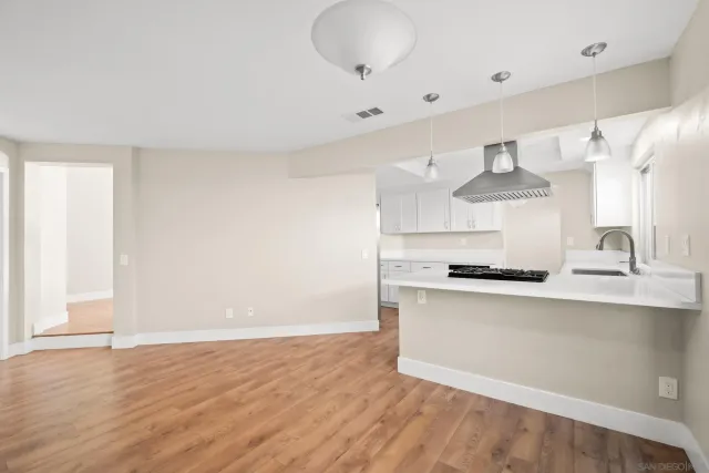 a kitchen with a stove a refrigerator and wooden floor