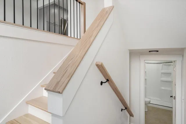 a view of staircase with white walls and railing