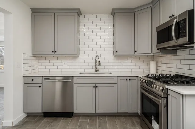 a kitchen with white cabinets stainless steel appliances and sink