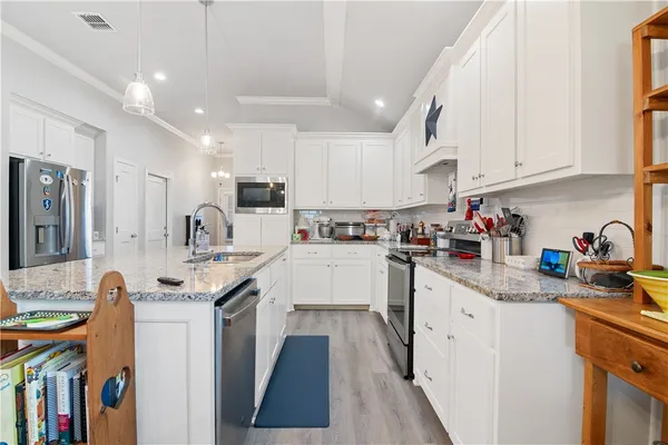 a kitchen with stainless steel appliances granite countertop a sink stove and cabinets