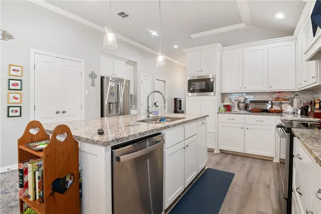 a kitchen with granite countertop a sink stove and cabinets