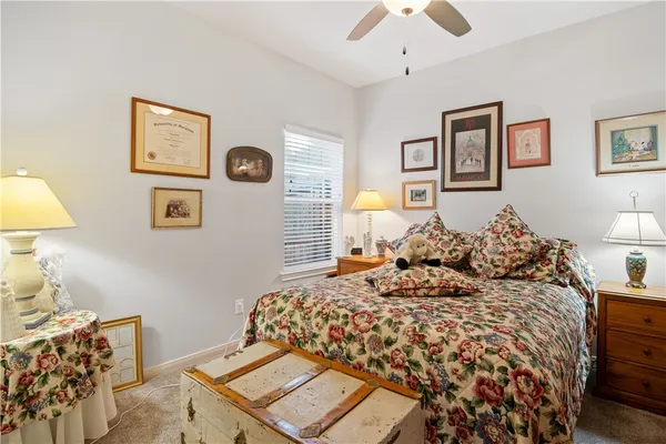 a bedroom with a bed and a lamp on dresser