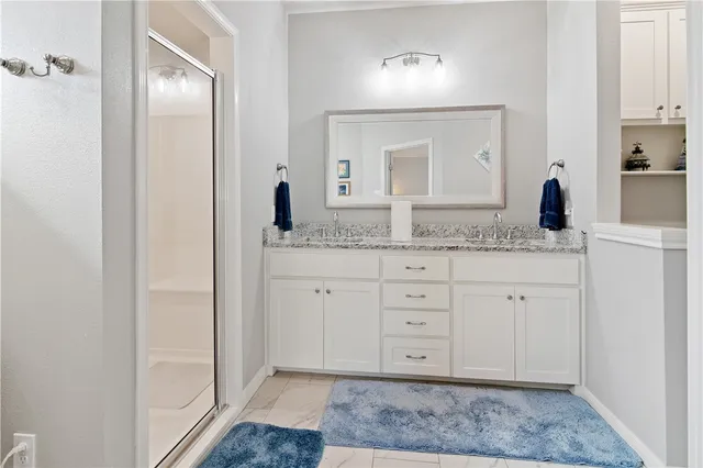 a spacious bathroom with a granite countertop sink and a mirror