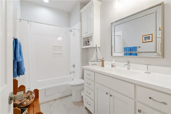 a bathroom with a double vanity sink a toilet and a mirror