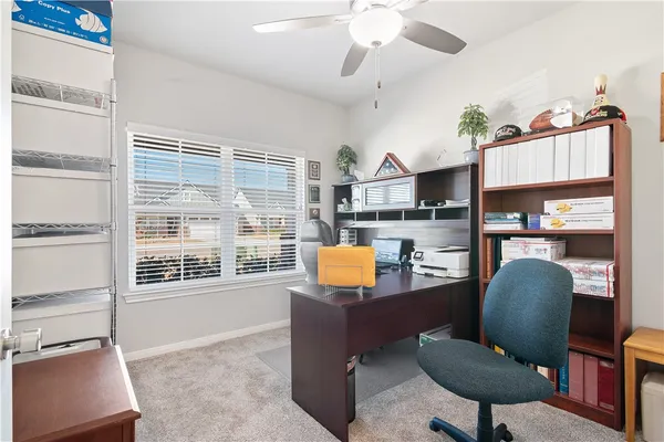 a view of a workspace with furniture and a window