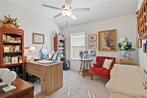 a living room with furniture a bookshelf and a window