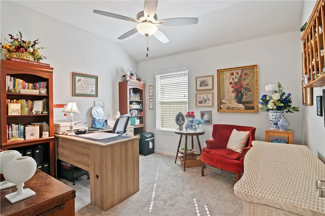 a living room with furniture a bookshelf and a window
