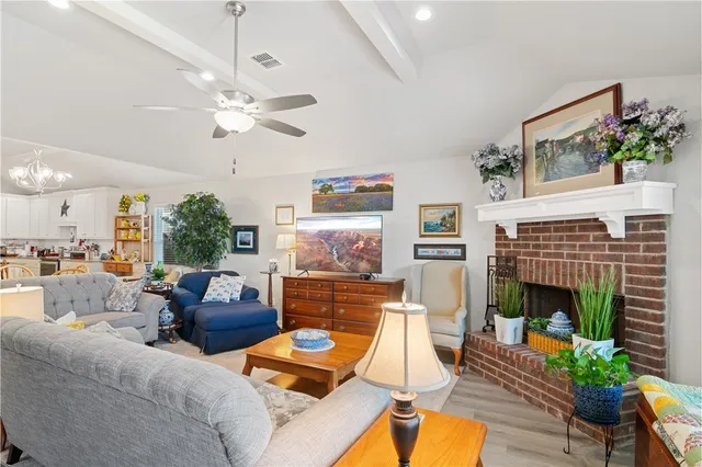 a living room with furniture a fireplace and a flat screen tv