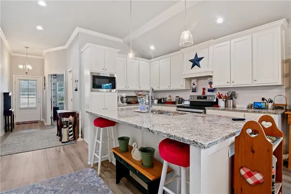 a kitchen with stainless steel appliances granite countertop a refrigerator and a stove top oven