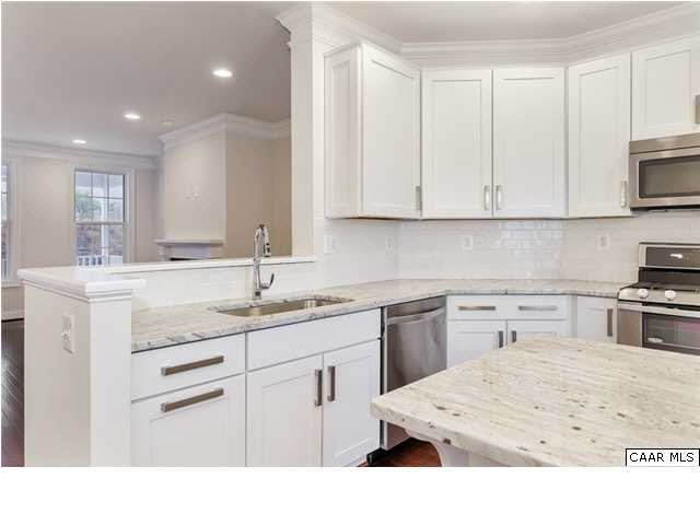 2106 Avinity Loop Charlottesville, VA 22902 - Photo 4 of 18 a kitchen with stainless steel appliances kitchen island granite countertop a sink dishwasher stove and white cabinets