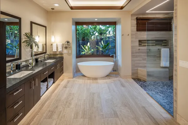 a bathroom with a double vanity sink a mirror and a bathtub
