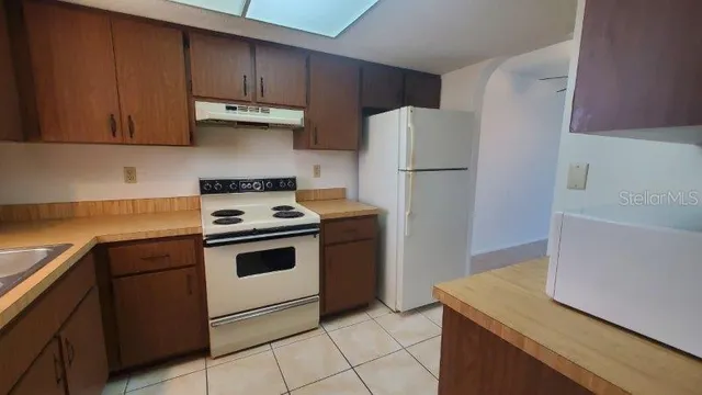 a kitchen with a stove a refrigerator and a sink