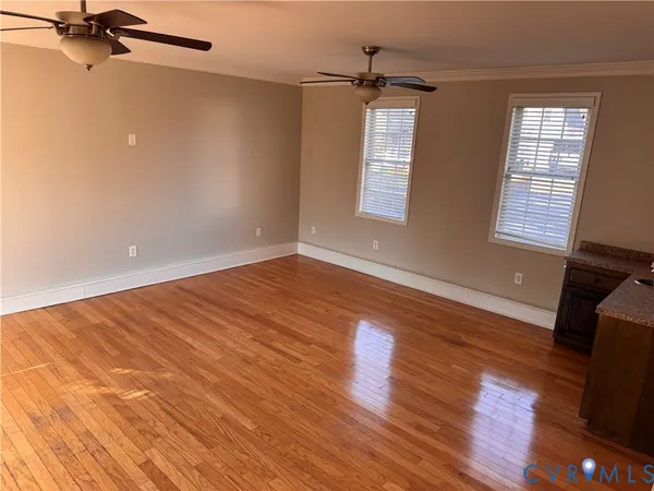 a view of an empty room with wooden floor