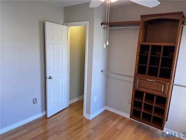 a view of an empty room with a window and a kitchen