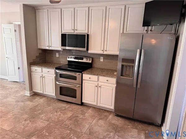 a kitchen with stainless steel appliances granite countertop a stove a sink and a microwave