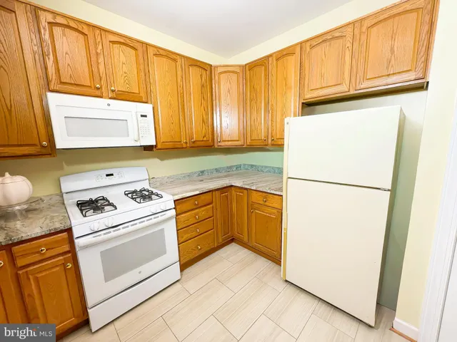 a kitchen with a refrigerator sink stove and cabinets