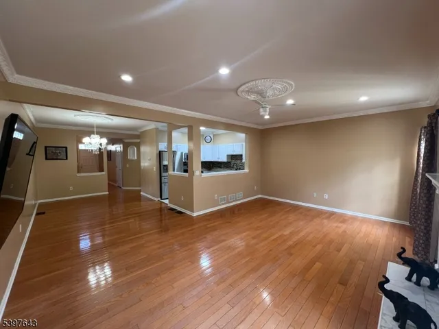 a view of a room with gym equipment and wooden floor