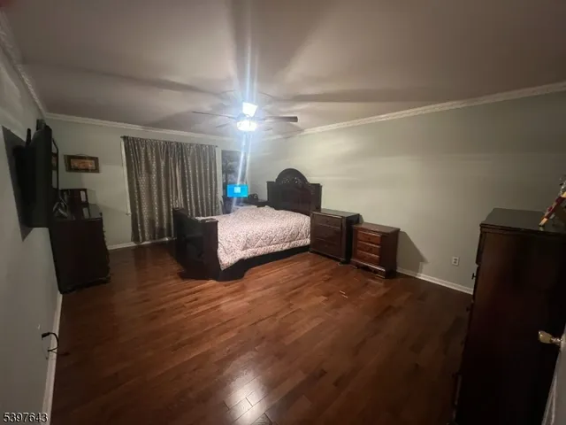 a view of a livingroom with a flat screen tv wooden floor and a window