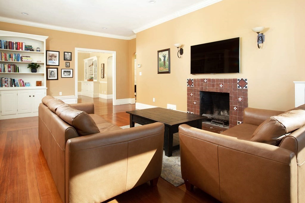 145 Salisbury Road, Unit 145 Brookline, MA 02445 - Photo 2 of 17 a living room with furniture a flat screen tv and a fireplace