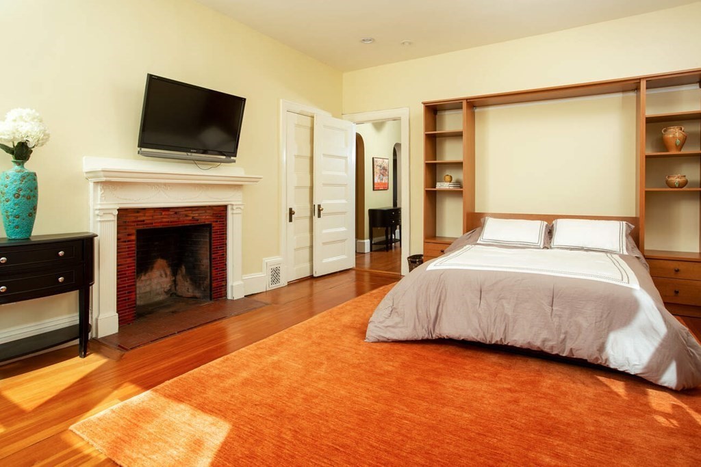 145 Salisbury Road, Unit 145 Brookline, MA 02445 - Photo 10 of 17 a spacious bedroom with a bed and a fireplace