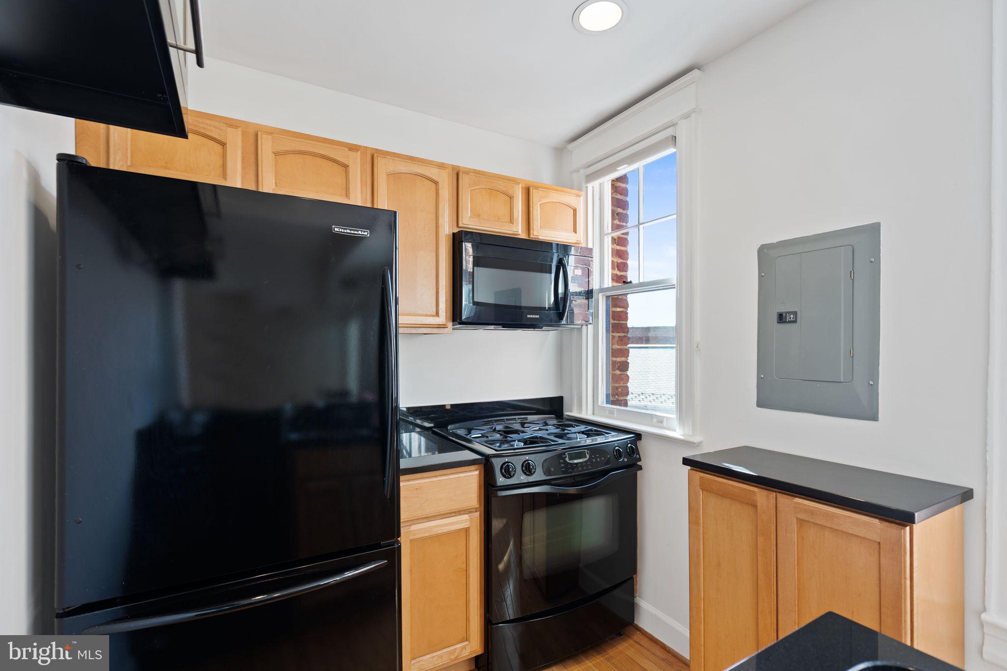 2902 Porter Street Northwest, Unit 43 Washington, DC 20008 - Photo 12 of 31 a kitchen with stainless steel appliances granite countertop a refrigerator and a stove top oven