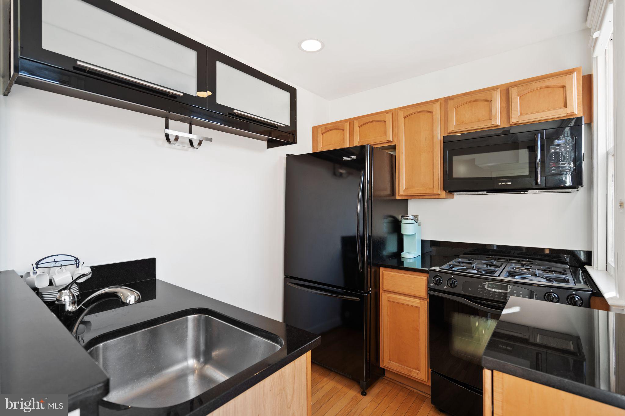2902 Porter Street Northwest, Unit 43 Washington, DC 20008 - Photo 10 of 31 a kitchen with stainless steel appliances granite countertop a refrigerator and a stove top oven