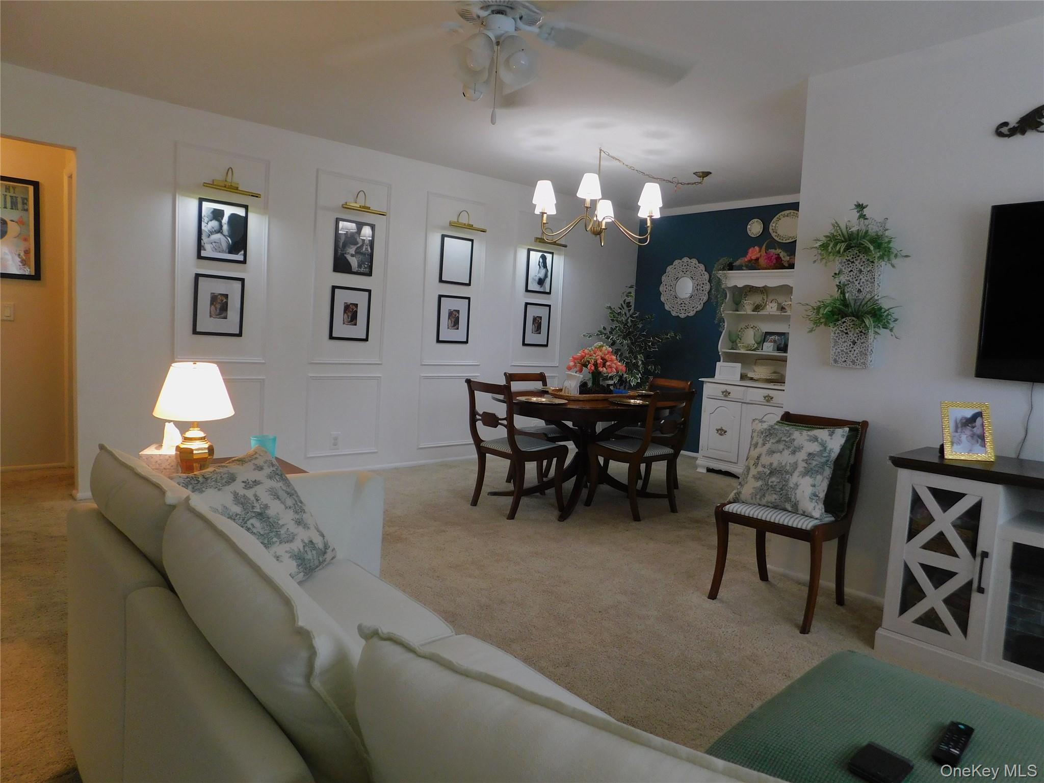 1879 Crompond Road, Unit #D15 Peekskill, NY 10566 - Photo 11 of 24 a living room with furniture a chandelier and a flat screen tv