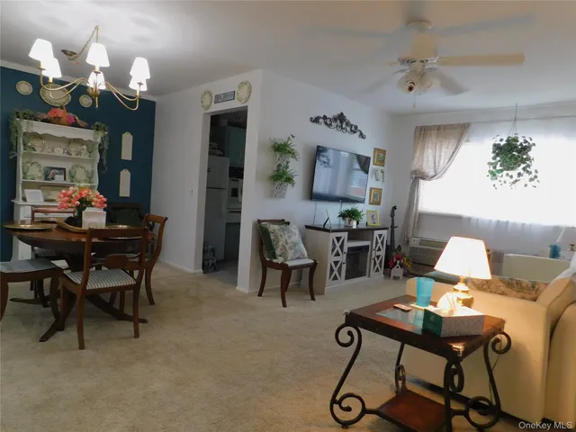 a living room with furniture a chandelier and a dining table