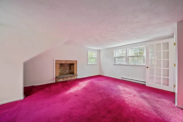a view of empty room with window and fireplace