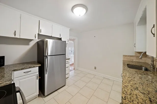 a kitchen with a refrigerator sink and cabinets