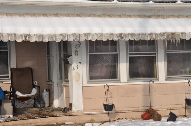 a view of a house with a chair and potted plant