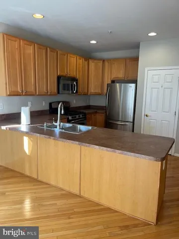 a kitchen with granite countertop a refrigerator a sink a stove a dining table and chairs