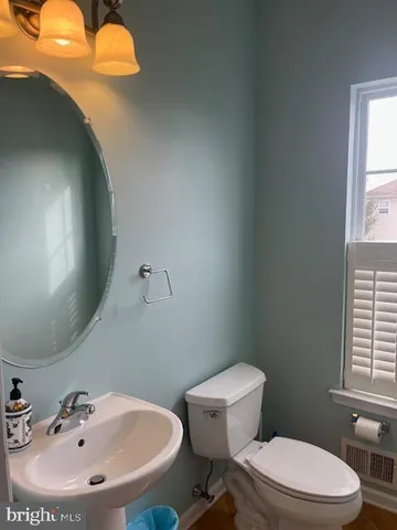 a bathroom with a sink mirror and toilet