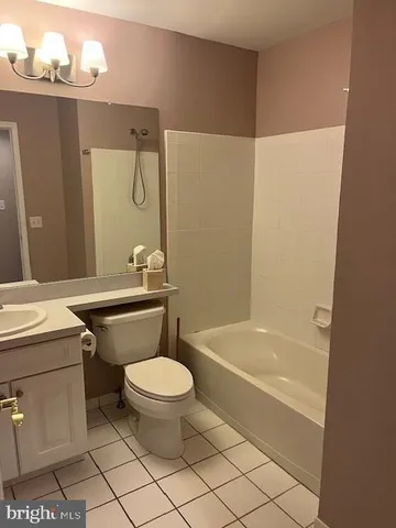 a bathroom with a granite countertop sink a toilet a mirror and bathtub