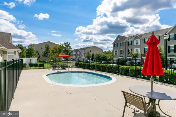 a view of a swimming pool with a patio and a yard