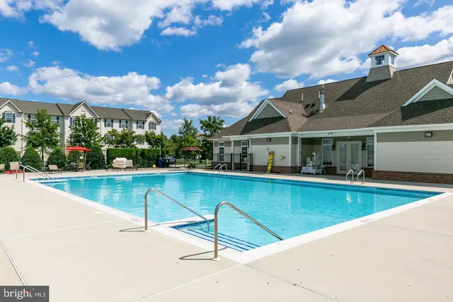 a view of a house with pool and chairs