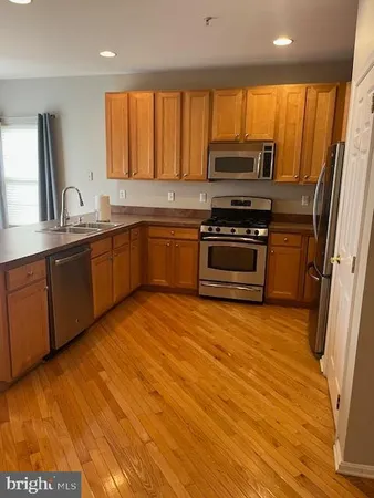 a kitchen with stainless steel appliances granite countertop a stove a sink and a refrigerator