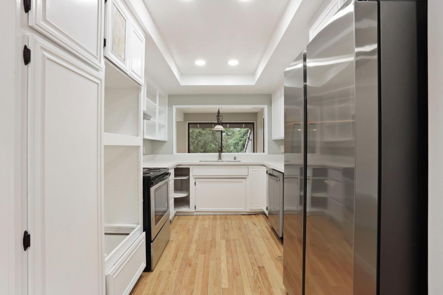 1917 Edgebrook Drive, Unit D Modesto, CA 95354 - Photo 22 of 58 a kitchen with a refrigerator and white cabinets