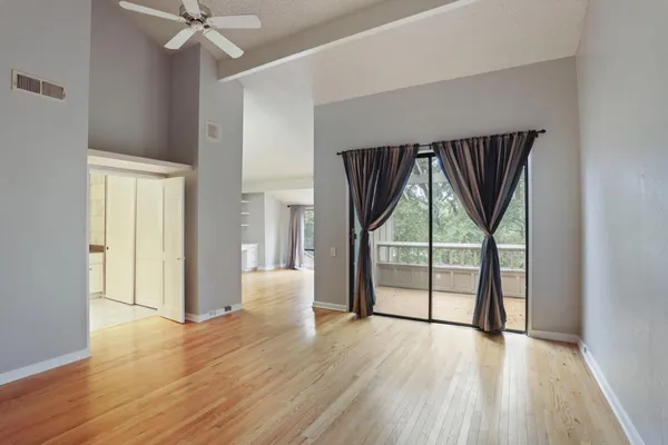 an empty room with wooden floor and windows