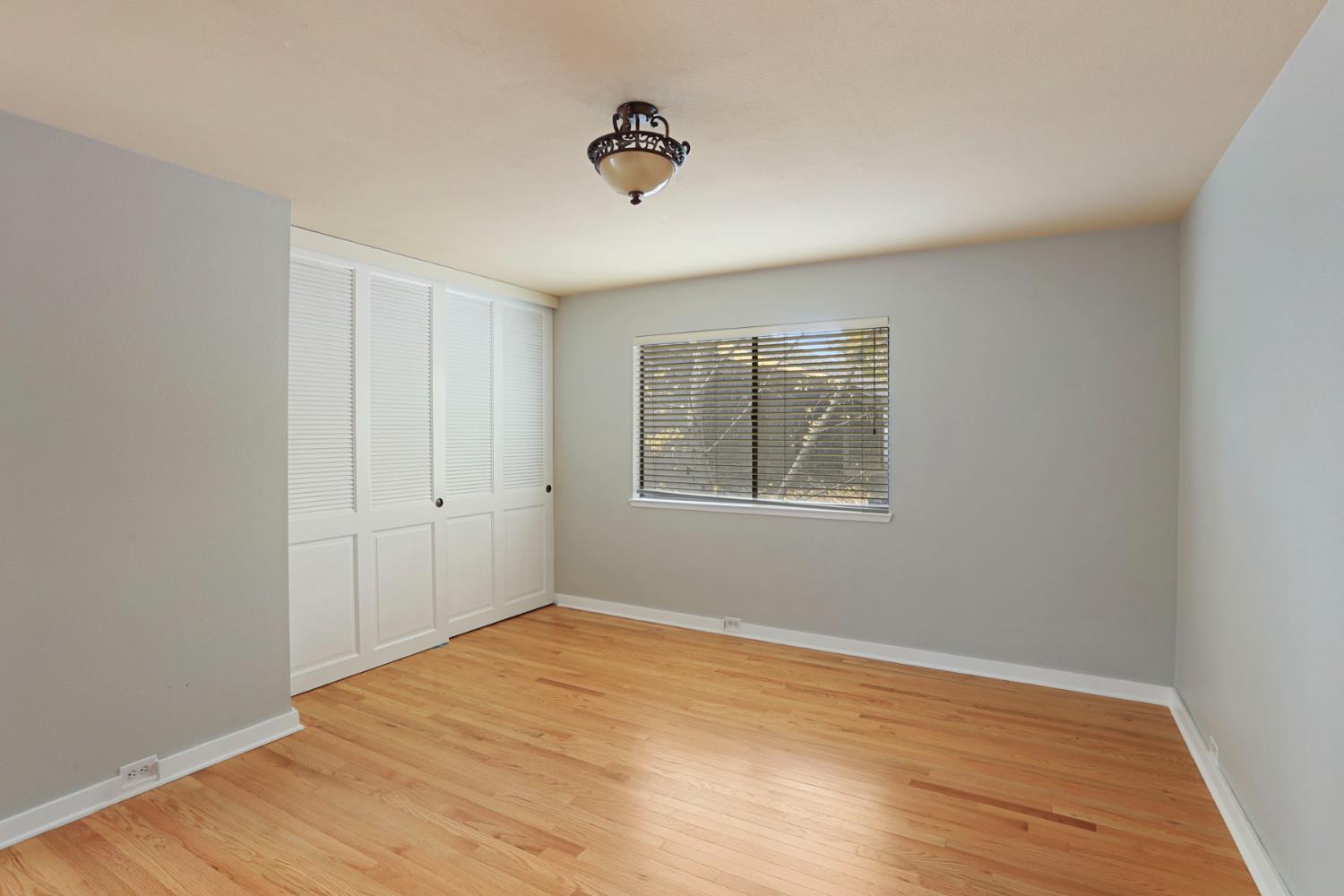 1917 Edgebrook Drive, Unit D Modesto, CA 95354 - Photo 42 of 58 a view of an empty room with wooden floor and a window