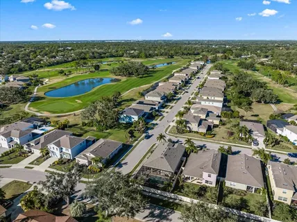 an aerial view of residential houses with outdoor space and lake view
