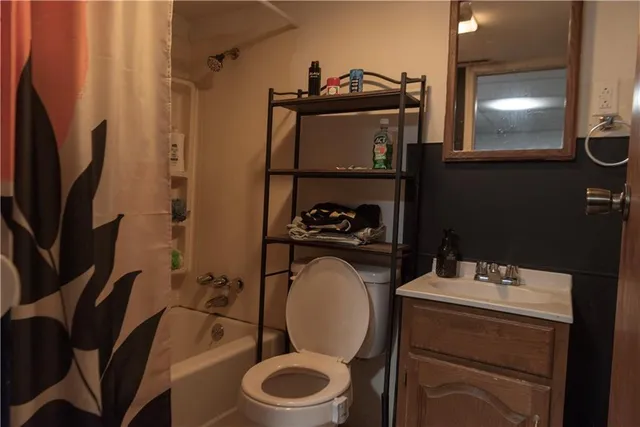 a bathroom with a toilet mirror and vanity