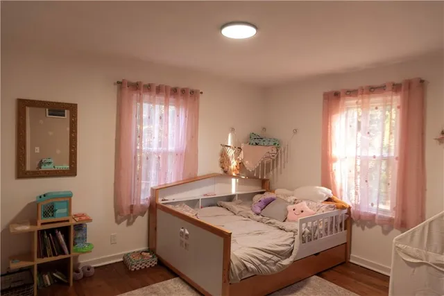 a bedroom with a bed and wooden floor