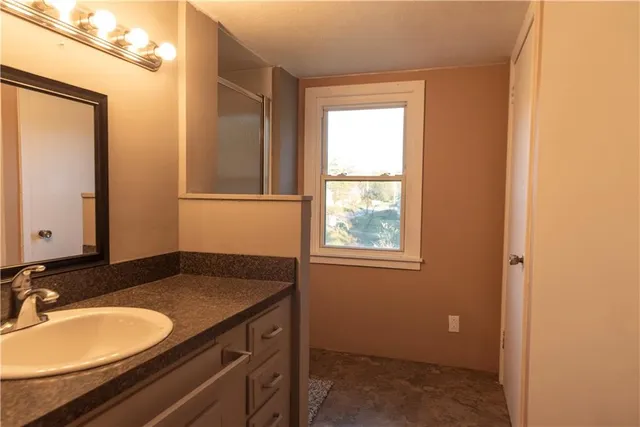 a bathroom with a granite countertop sink and a mirror