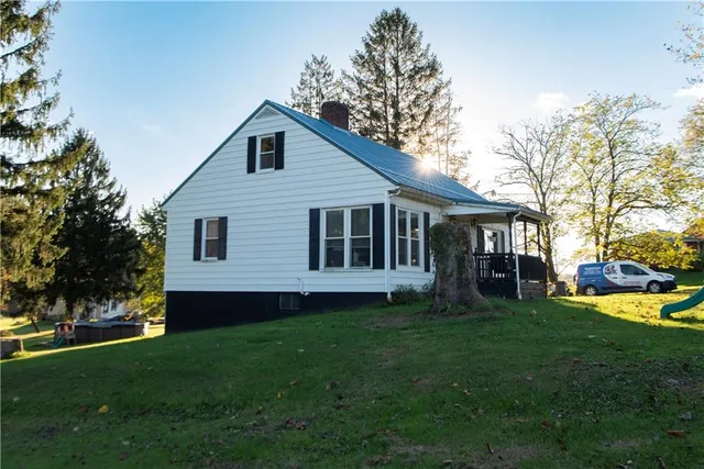 a view of a house with a yard and sitting area