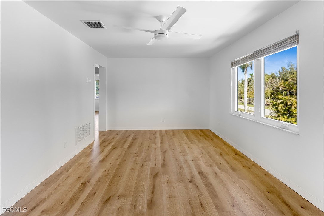 10697 Holly Road Bokeelia, FL 33922 - Photo 17 of 50 wooden floor in an empty room with a window