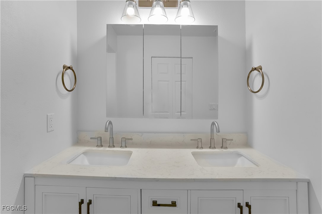 10697 Holly Road Bokeelia, FL 33922 - Photo 25 of 50 a bathroom with a sink and a mirror