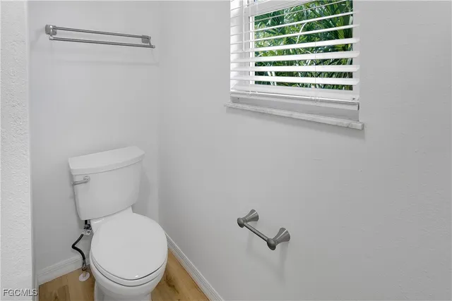 a white toilet sitting next to a window