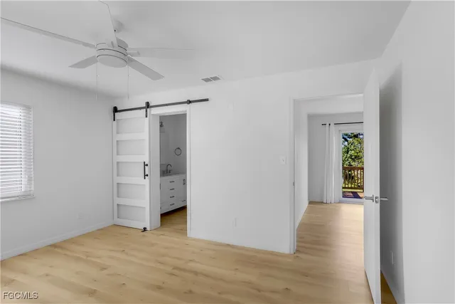 a view of an empty room with closet and a window